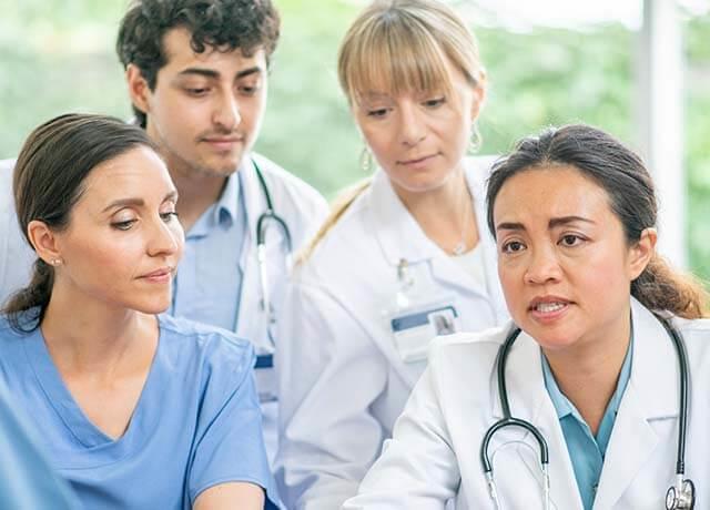 A group of nurses and doctors talking to each other.