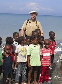 Dr. Tim Bristol surrounded by a group of young children in Haiti.