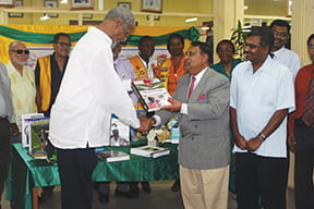 Dr. Shamir Andrew Ally presents books to the University of Guyana library.
