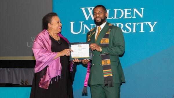 Chima Onwuka (right) receives Walden’s Citizenship Award from Board of Directors Chair Toni Freeman. 